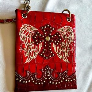 Red with silver hardware crossbody. Cross and angel wings.